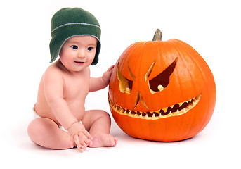 Image showing Young Boy Sits in Diaper with Carved Halloween Pumpkin