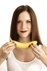 Image showing Banana Showing in Manicured Hands of Beautiful Brunette Woman