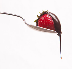 Image showing sweet fruit strawberry in chocolate syrup on silver spoon