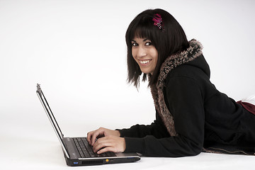 Image showing Woman Types Work on Laptop Computer Laying on Floor