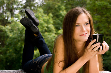 Image showing Woman Ponders Thought with Coffee Cup in the Park