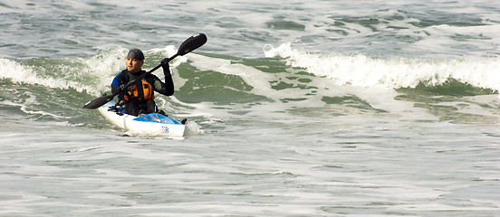 Image showing Man Sea Kayak Rides Pacific Ocean Wave into Oregon Shore