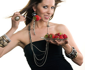 Image showing Woman eats RAW fruit Food Strawberries from Glass Plate