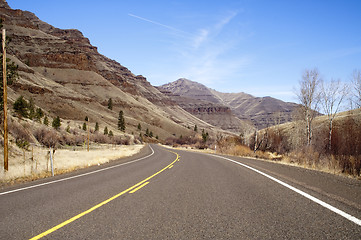 Image showing Lonely Two Lane Divided Highway Cuts Through Dry Mountainous Lan