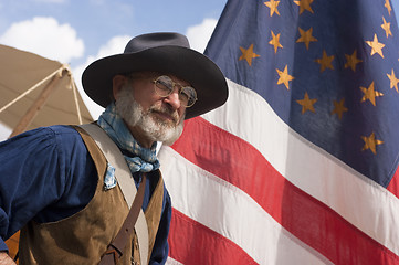 Image showing Civil War Re-enactment Scout Stands By Flag In Army Camp