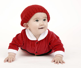 Image showing Infant Boy Sits up on Hands LOOKING out under his red hat