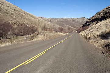 Image showing Lonely Tow Lane Divided Highway Cuts Through Dry Hills Landscape