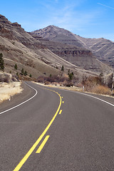 Image showing Lonely Two Lane Divided Highway Cuts Through Dry Mountainous Lan