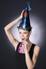 Image showing Party Girl Wears Decorated Hat Blowing Noise Maker