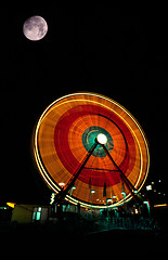 Image showing Fair Moon Full Lunar Showing over Local Fair Midway Canival Ride