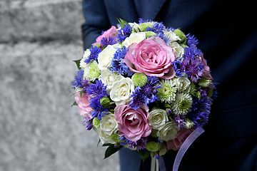 Image showing groom holding a bouquet