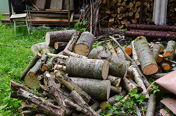 Image showing pile of chopped logs branche to woodshed in garden 