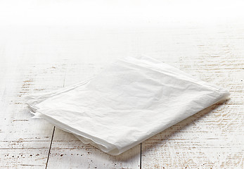 Image showing white wrapping paper on wooden table
