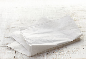 Image showing white wrapping paper on wooden table