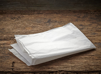 Image showing white wrapping paper on wooden table