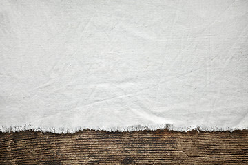Image showing old white cotton tablecloth on wooden table