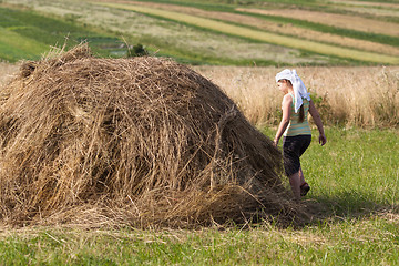 Image showing Girl and hay on field in sunset