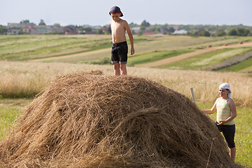 Image showing Children and hay on field in sunset