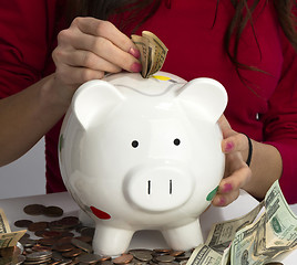 Image showing Woman Fills Savings Piggy Bank American Currency Cash Coins Weal