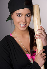 Image showing Pretty Female Baseball Lover Holds A Wooden Bat and Smiles