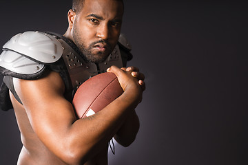 Image showing Angry African American Male Football Player Holds Ball Tight