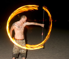 Image showing Shirtless Man on Beach Spins Burning Rod Playing with Fire