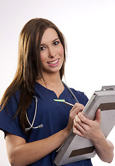 Image showing Beautiful Brunette Nurse Records Patient Medical Chart Data on C