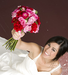 Image showing Bouquet Raised in Air By Bride Wearing White Wedding Gown