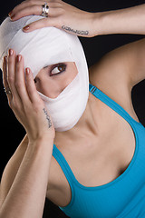 Image showing Female Holds Face First Aid Gauze Wrapped Head Injury Pain