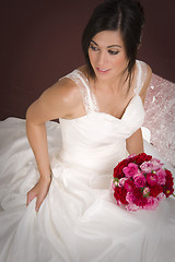 Image showing Bride in Bridal Gown Wedding White Dress Sitting with Bouquet of