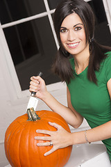 Image showing Excited Woman Cutting Carving Halloween Pumpkin Jack-O-Lantern