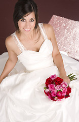 Image showing Bride Sitting in White Wedding Dress with Flower Bouquet Red Ros