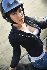 Image showing Sassy Young Woman Sitting Sideways on Motorcycle Seat in Alley