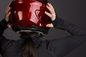 Image showing Woman Places the Red Full Face Motorcycle Racing Helmet on Head