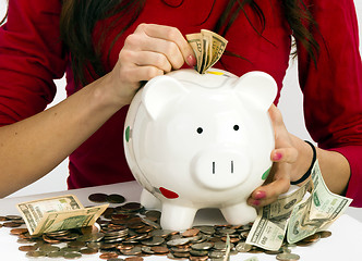 Image showing Woman Stuffing US Currency Coins Piggy Bank Cash Savings