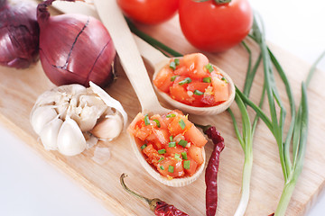 Image showing Salsa in two spoons on a wooden board and ingredients