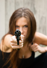 Image showing Brunette Woman Points Gun Spent Chamber Ready to fire