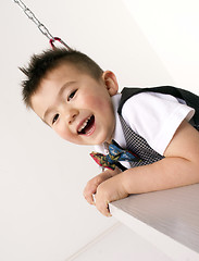 Image showing Vertical Composition Happy Young Boy Playing on Chain Swing Set