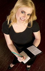 Image showing Young Attractive Female Server Writes and Order in the Restauran