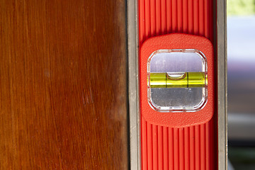 Image showing Old Door Gets Installed Leveled up By Long Orange Level Tool