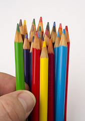 Image showing Fingers Touch a Green Color Pencil from A Group