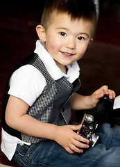 Image showing Happy Young Boy in Vest Plays Around With Vintage Camera
