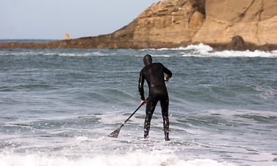 Image showing Man Black Wetsuit Ocean Surf Riding Paddle Board Summer Sport