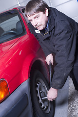 Image showing Automotive Technician Auto Mechanic Loosens Lug Nut Front Tire