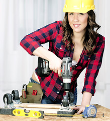 Image showing Woman Works on a Bench Repairing A Dolly