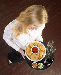 Image showing Young Attractive Female Server Brings Wine and Appetizer Food Tr