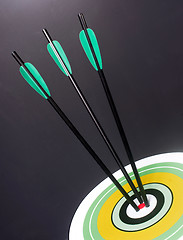 Image showing Three Green Black Archery Arrows Hit Round Target Bullseye Cente