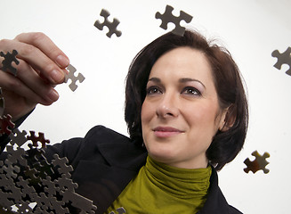 Image showing Business Woman Working a Jigsaw Puzzle