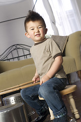 Image showing Happy Young Boy Plays Beats Kitchen Pots Pans Like Drums