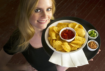 Image showing Young Attractive Female Server Brings Appetizer Chips Salsa Food